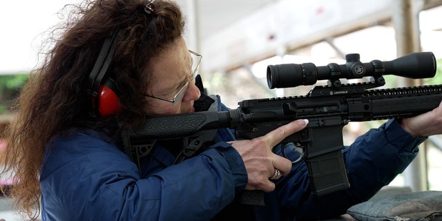 Woman learns to shoot AR-15 at outdoor rifle range