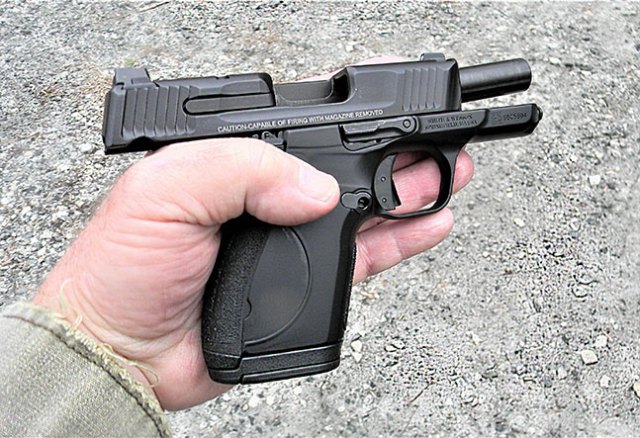 Small to average hands holding the Smith and Wesson CSX with the slide locked to the rear