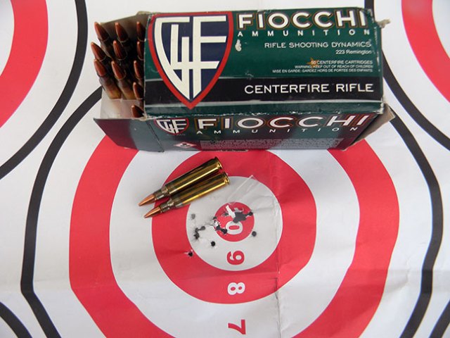 Bullseye target with bullet holes in the 10 and 9 rings with a box of Fiocchi ammunition