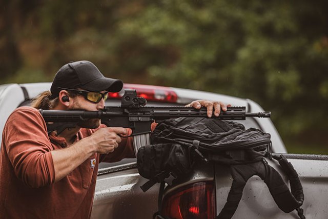 Using a backpack as a pad while shooting a Del-Ton Echo 316M AR-15 over a truck bed