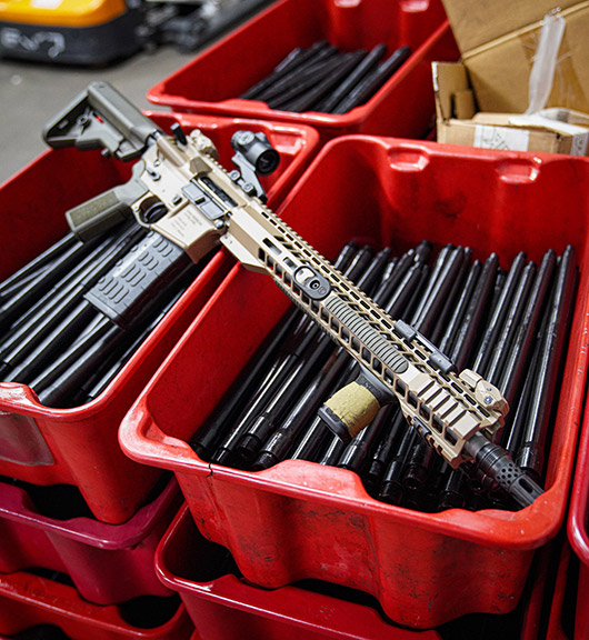 Radical Firearms RF-15 in tan on boxes of spare barrels