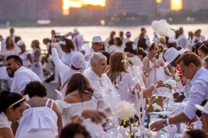 Dinner party has guests bringing tables, dressing in white and learning location last-minute