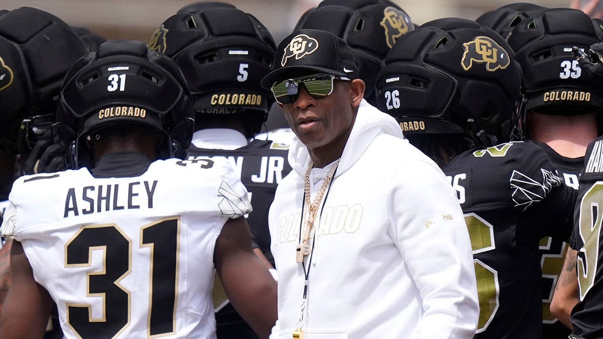 Colorado Buffaloes head coach Deion Sanders standing on the field at Folsom Field