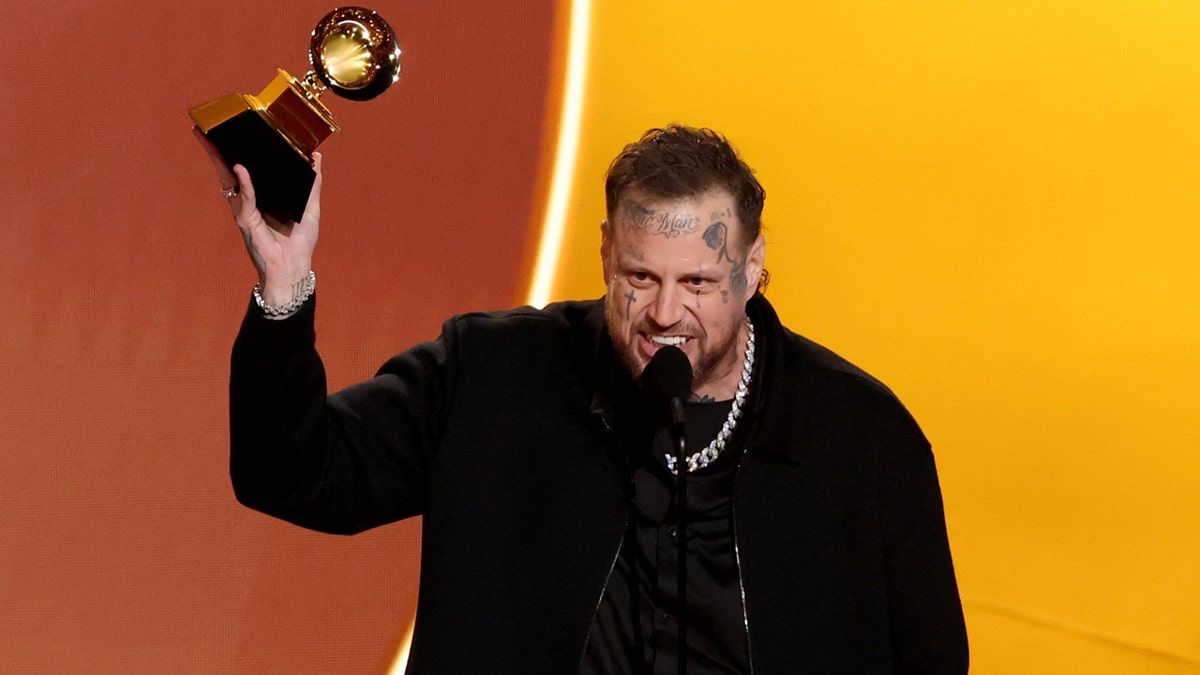 Jelly Roll standing on a stage holding a Grammy Award during an awards ceremony.