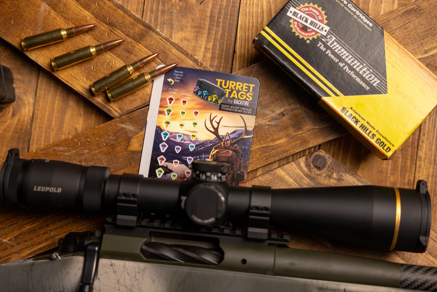 Backfire Turret Tags on card backer with rifle scope before heading to the range for testing