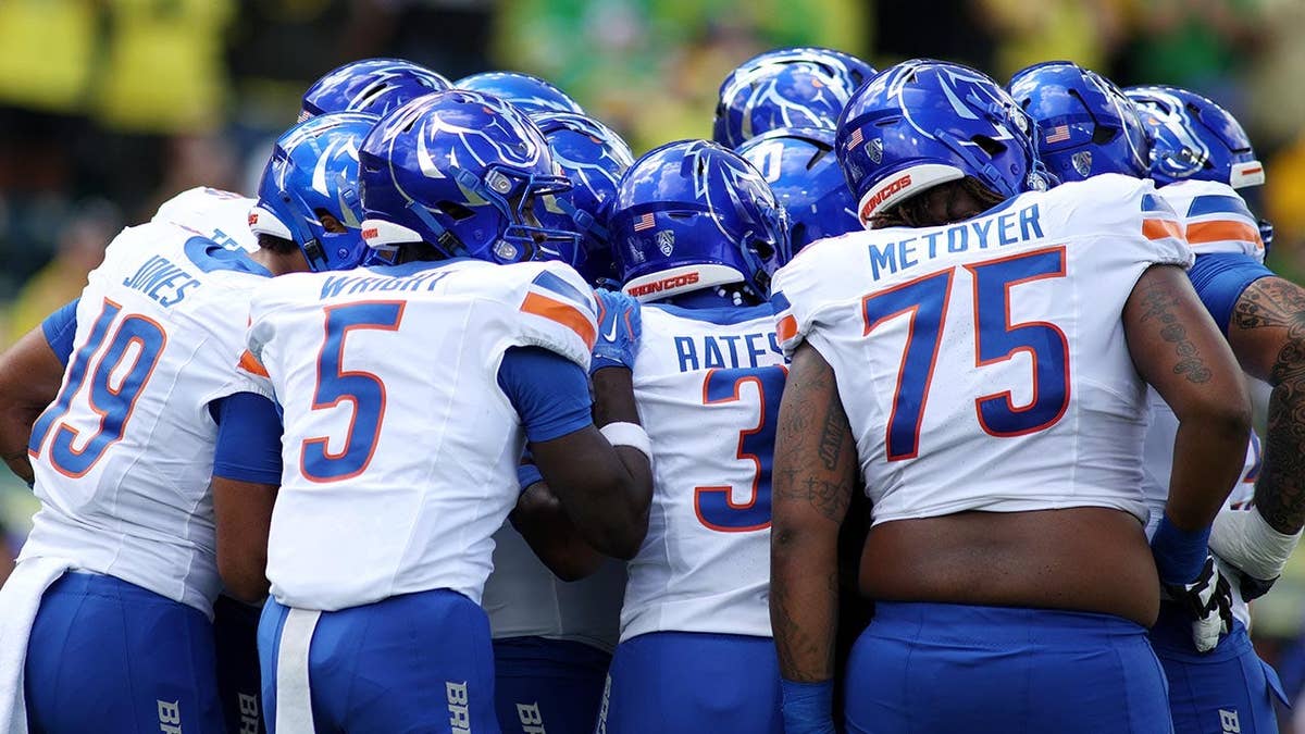 The Boise State football team huddle during a game