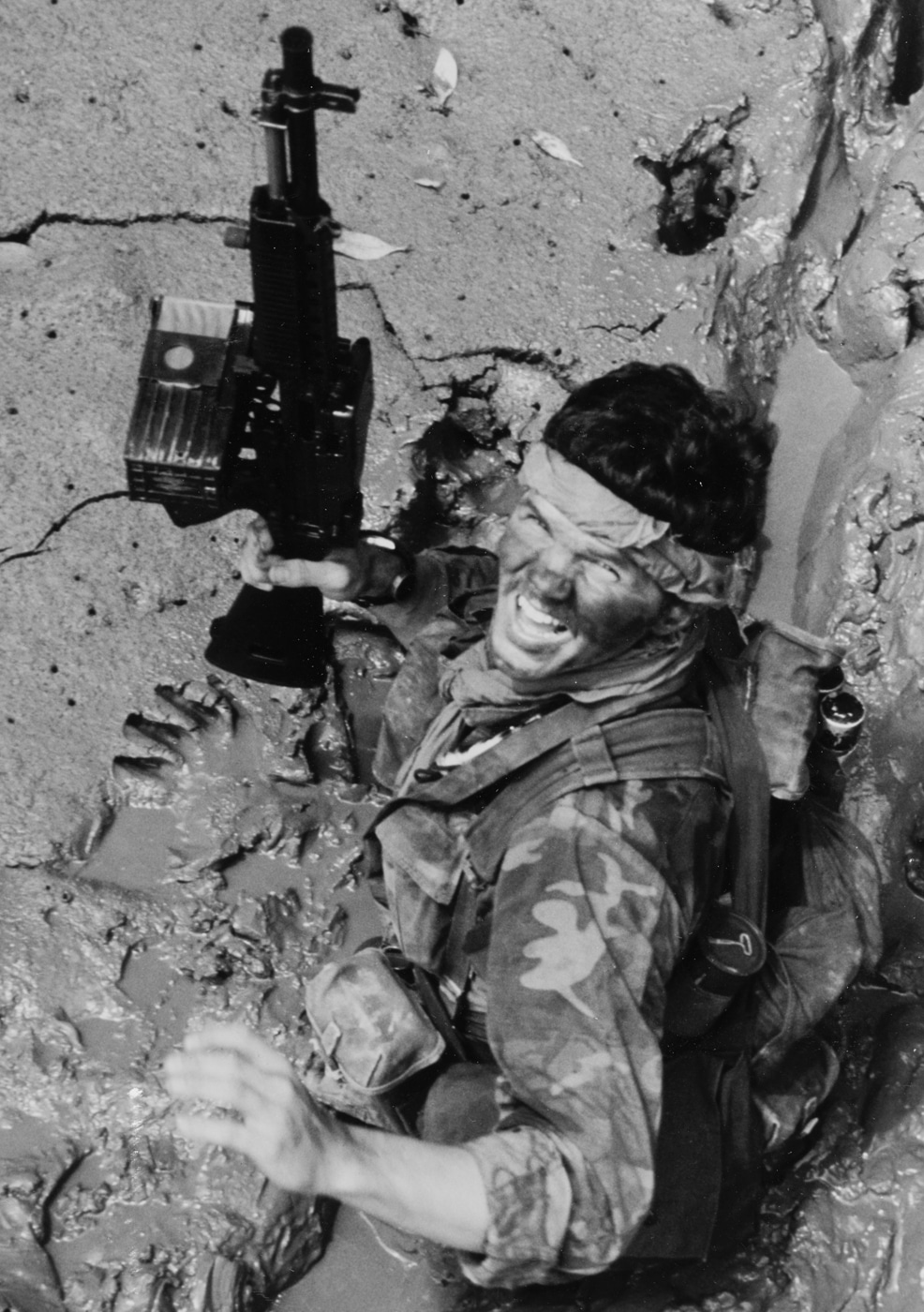 Navy SEAL with Stoner 63 machine gun moves through mud in Vietnam