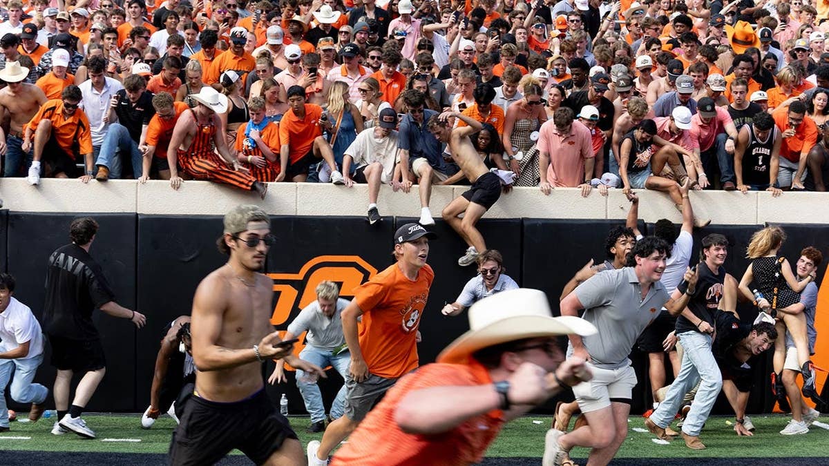 Oklahoma State football fans storm the field after a game