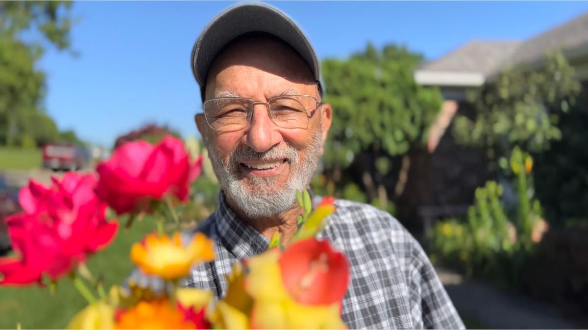 Zafar Nomani holds a bouquet of flowers.