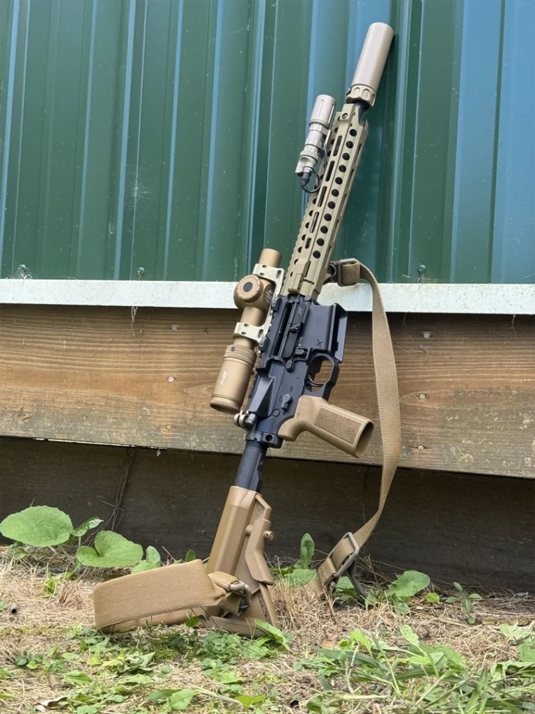 author's carbine with sling, lpvo, light, leaning on a range building