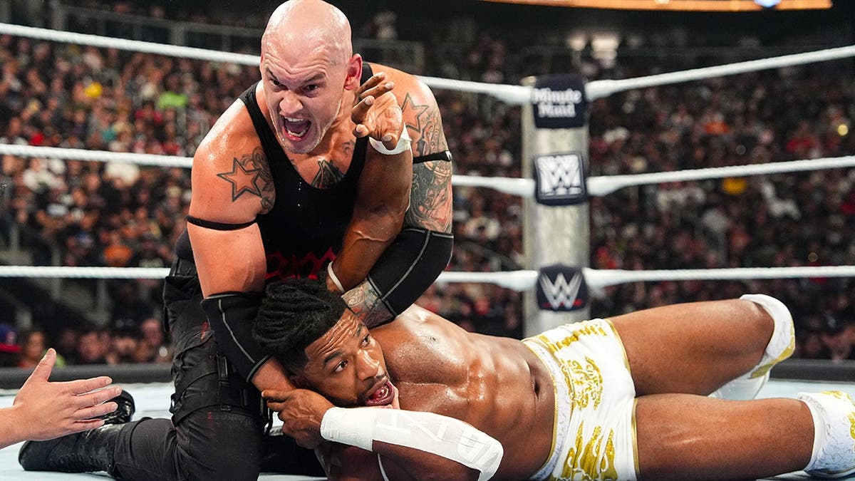 Baron Corbin wrestles Trick Williams in the ring.