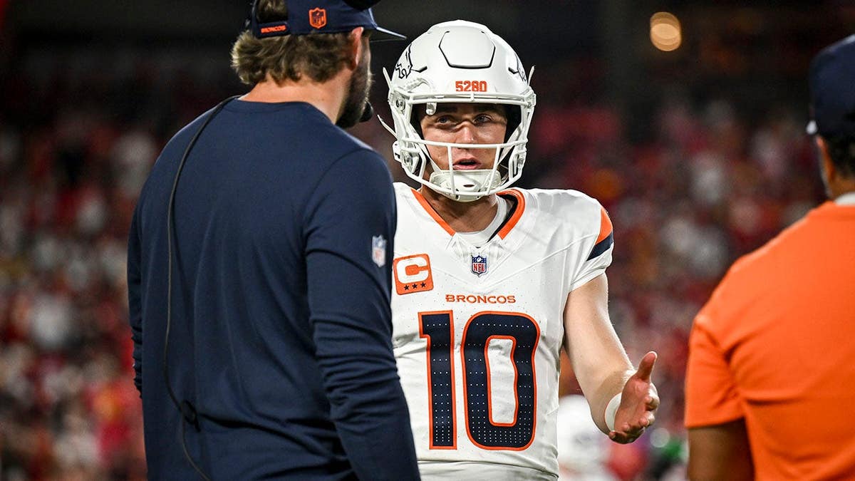 Bo Nix speaks to Davis Webb during a game against the Kansas City Chiefs.