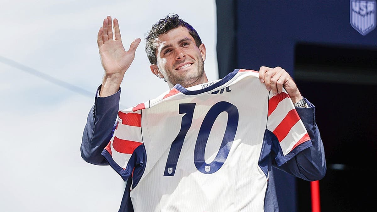 Christian Pulisic posing with his United States soccer jersey in New York City