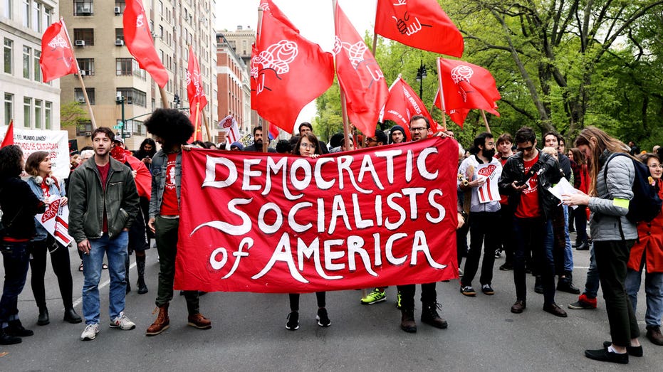 People hold a Democratic Socialists of America sign.
