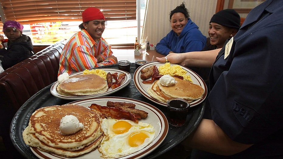 Denny's waitress Tahmina Najemyar delivers free Grand Slam breakfasts to guests.
