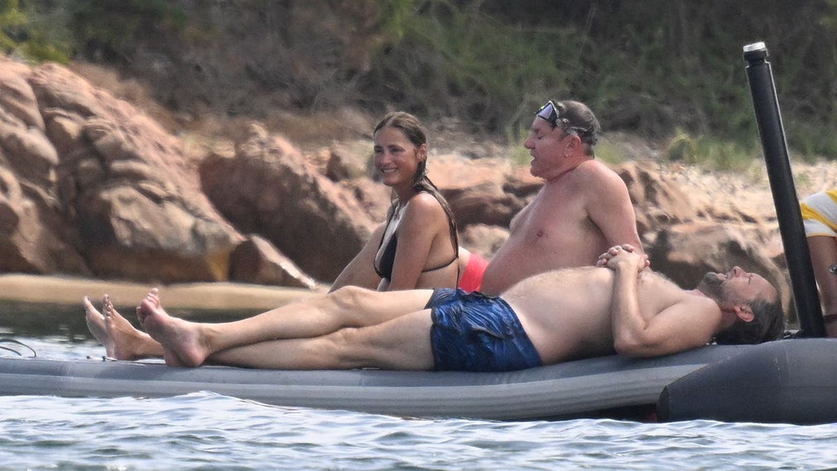 Yasmin and Simon Le Bon sitting on a boat after taking a dip in the ocean together.