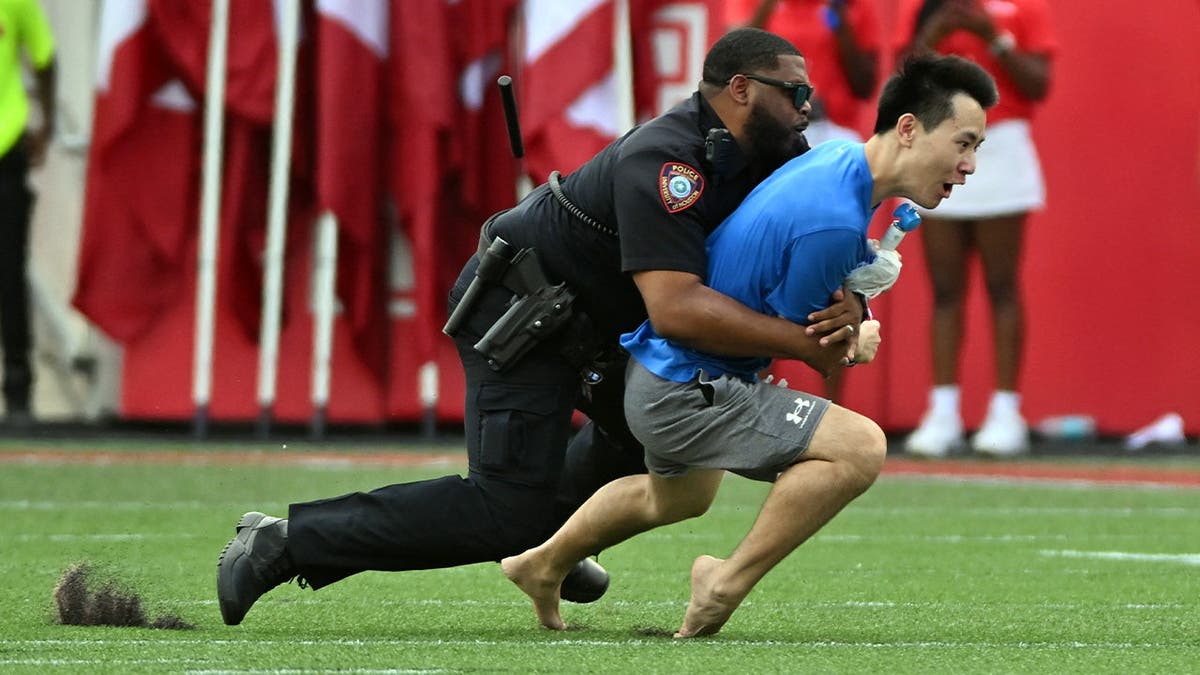 Police officer tackling fan