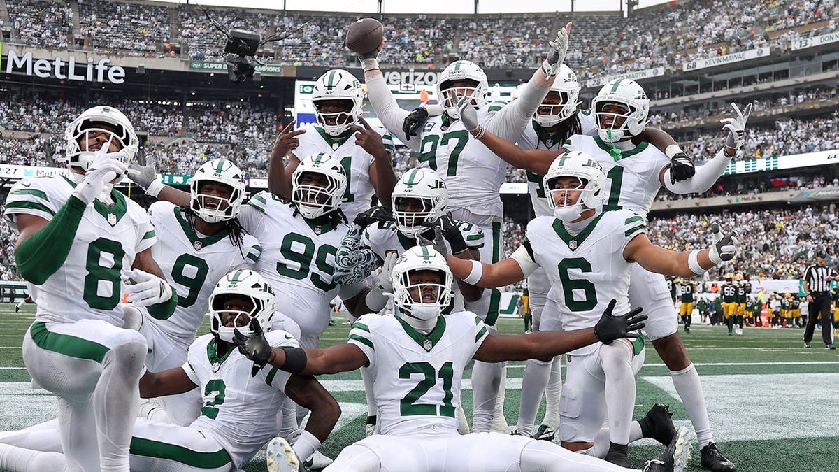 New York Jets defensive players celebrate after recovering a fumble during a game at MetLife Stadium.