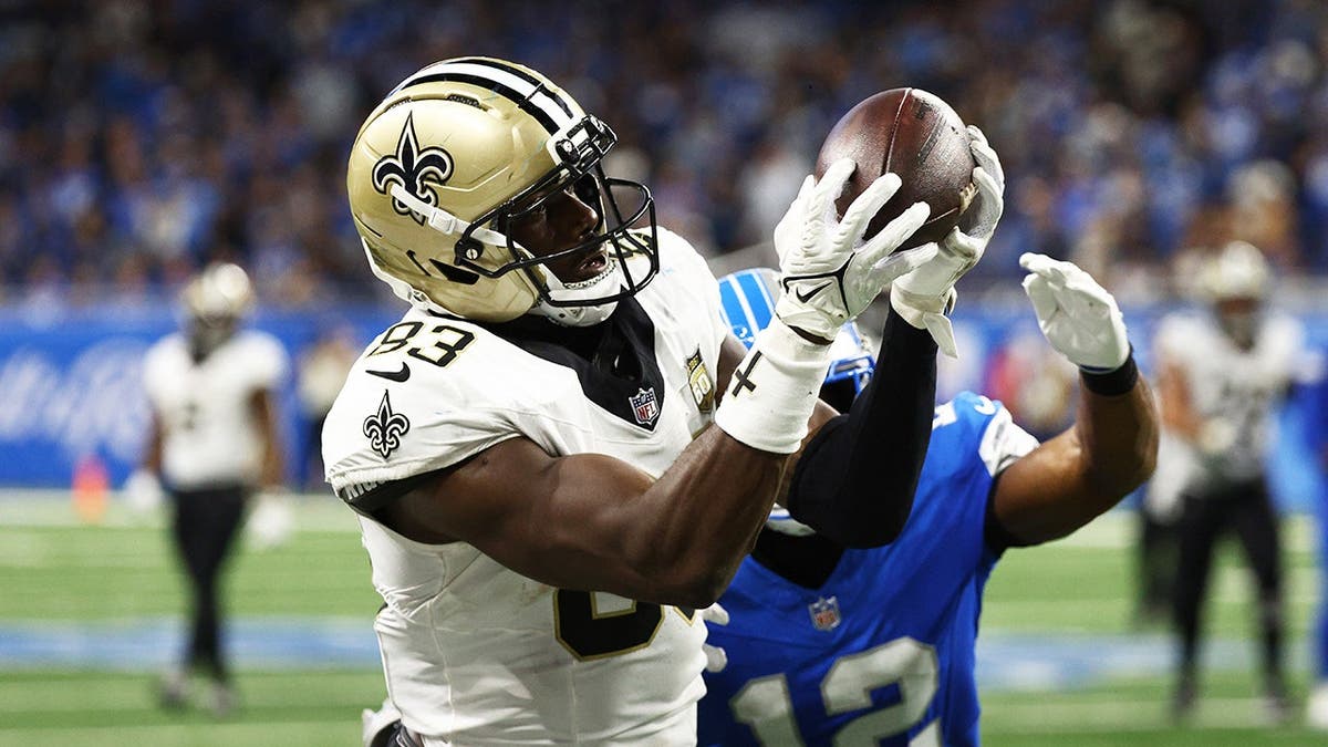 Juwan Johnson catches a pass against Thomas Harper during overtime at Ford Field.