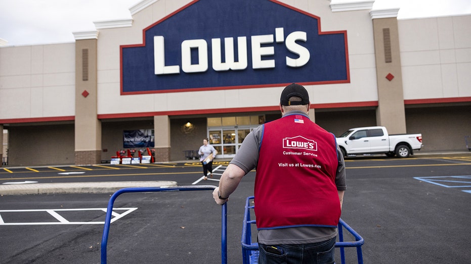 Lowe's worker pushes cart in front of store