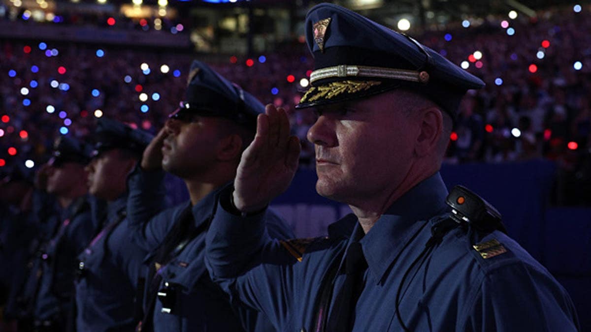 Service members salute the flag during the national anthem at MetLife Stadium.