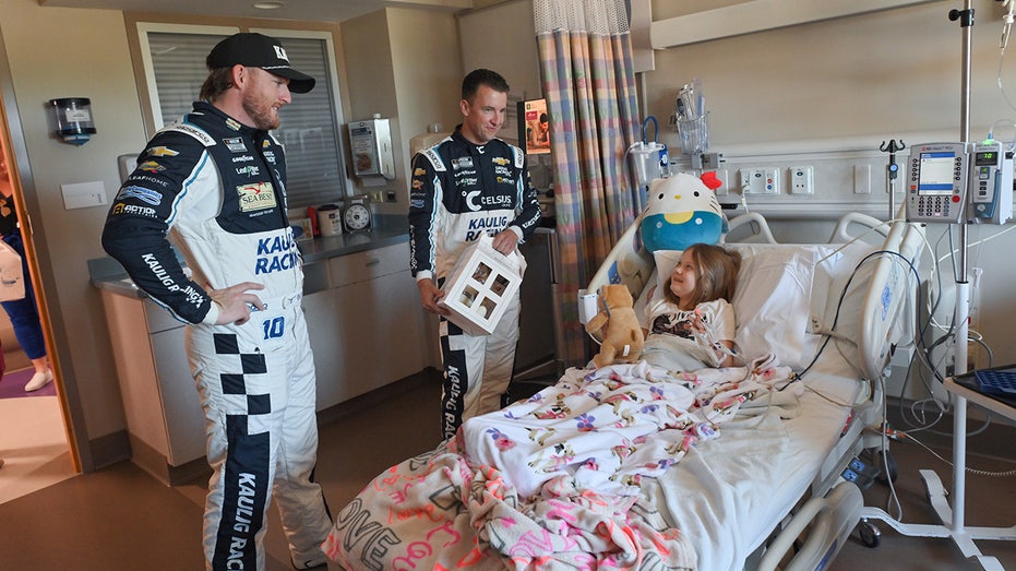 Drivers meet with child at hospital during Speedy Bear Brigade