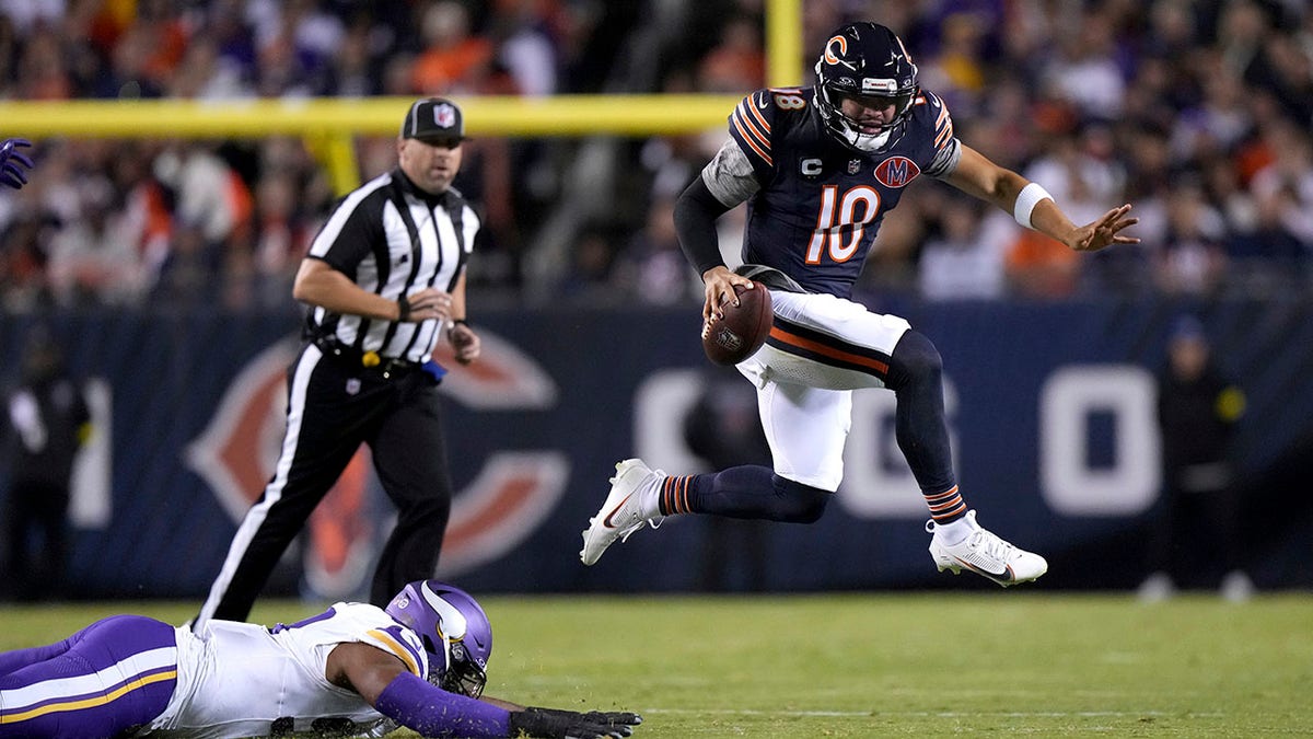 Caleb Williams runs past Minnesota Vikings defensive lineman Jonathan Allen, left, during the first half of an NFL football game Monday, Sept. 8, 2025, in Chicago.