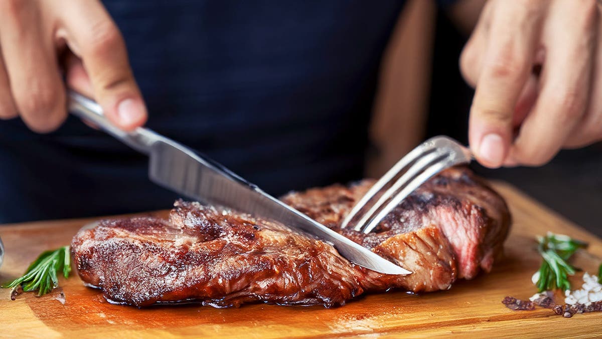 A person cuts into a steak.