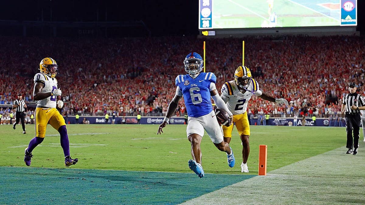 Trinidad Chambliss of the Mississippi Rebels scores a touchdown against Ty Benefield of the Louisiana State Tigers.