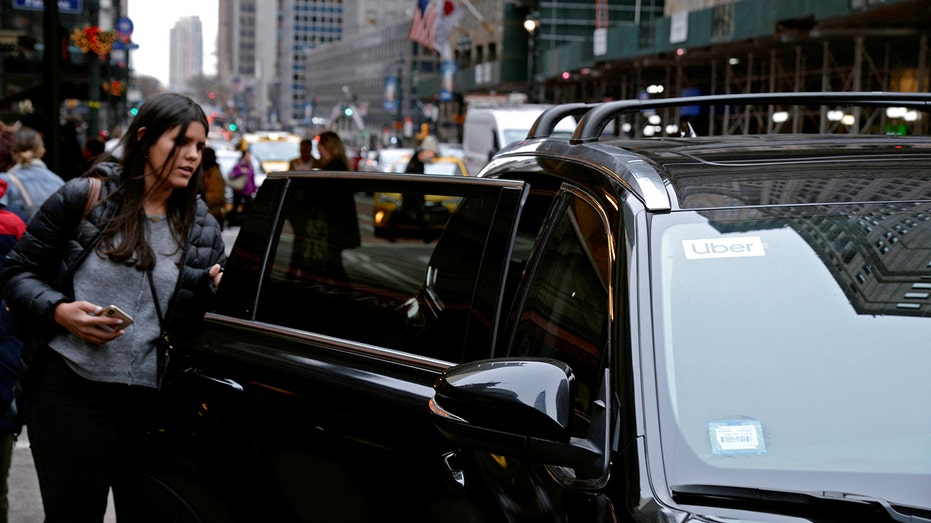 A passenger enters an Uber car