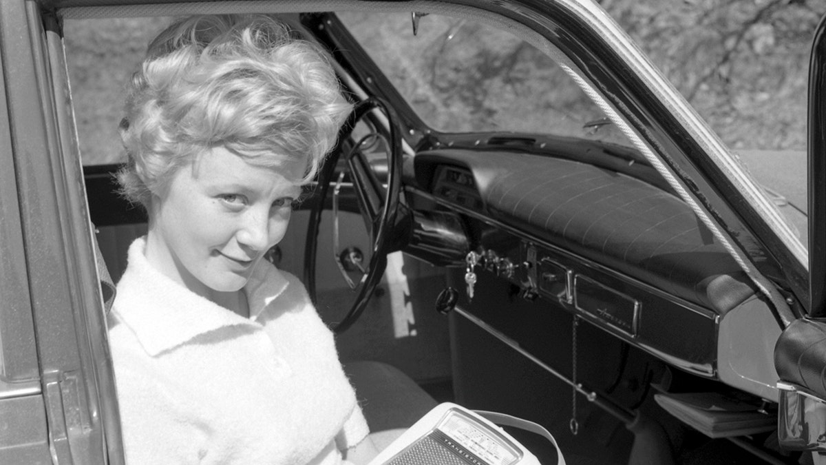 In the 1960s. A young woman in a car listening to a portable radio. Battery operated transistor radio with AM and FM bands. The radiostations and frequenses are displayed on the front, and a knob to turn and adjust to get best possible reception. Sweden 1960 Conard ref 4220 (Photo by Sjöberg Bildbyrå/ullstein bild via Getty Images)