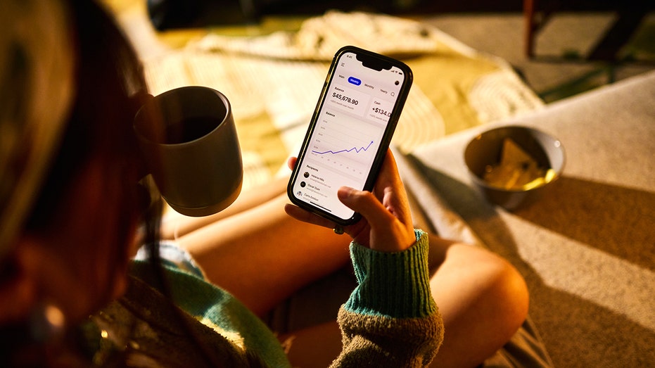 A person checks the performance of an investment portfolio on a smartphone.