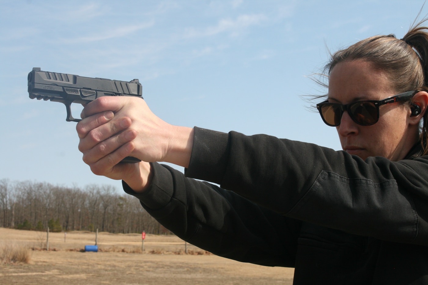 woman shooting a pistol with a solid two-handed grip