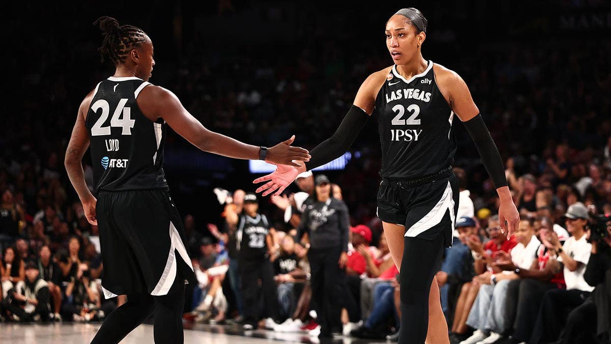 Jewell Loyd and A'ja Wilson high five during a WNBA playoff game.