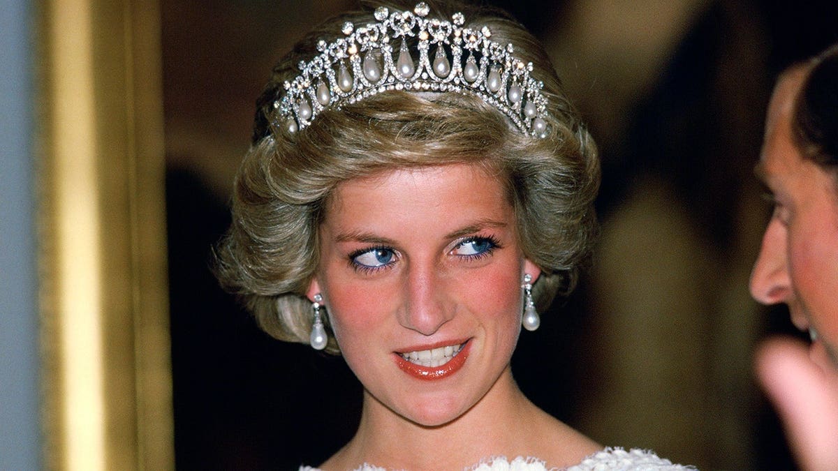 Diana, Princess of Wales, talks to her husband at the British Embassy in Washington.