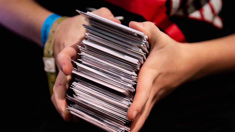 kid holds trading cards